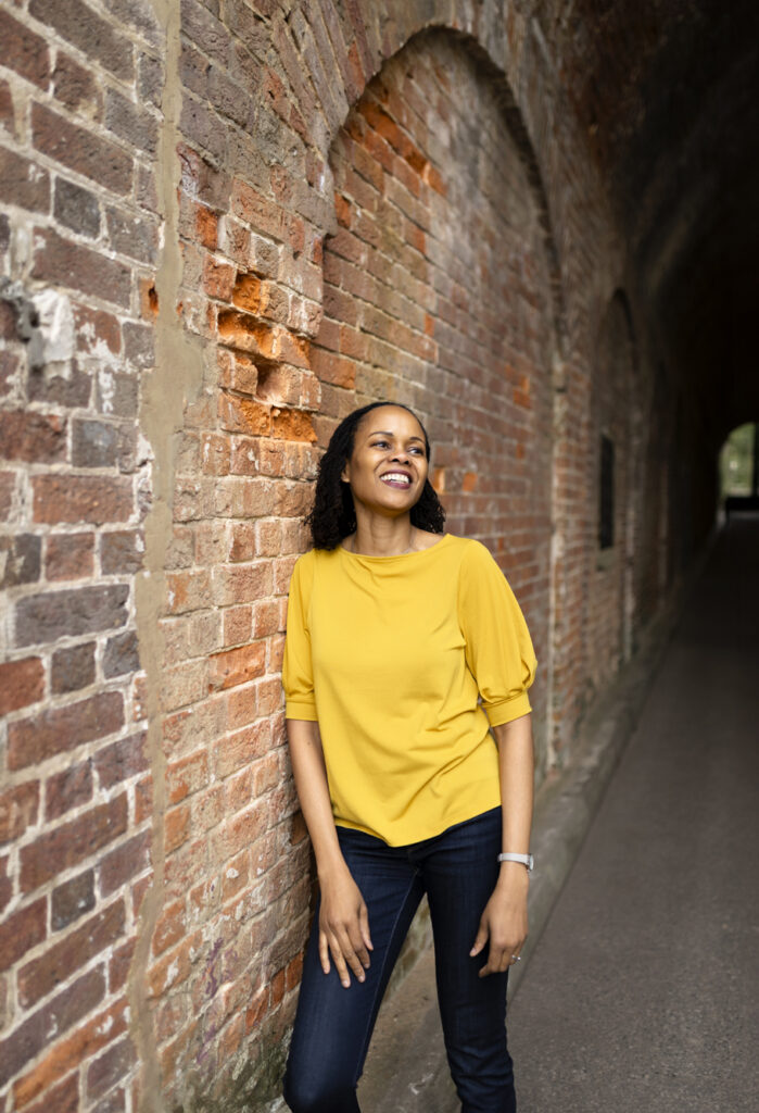 woman leaning against brick wall in reigate, surrey.